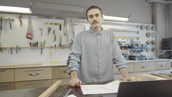 Self-Employed Caucasian Carpenter Posing in Furniture-Making Workshop