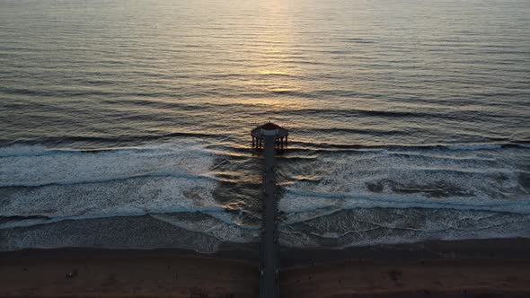 Manhattan Beach Pier at sunset in California, America. Cinematic aerial view