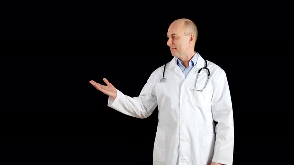 Bald Doctor in Medical Gown Showing Hand To Somewhere While Presentation on Black Background