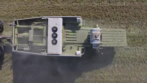 aerial hay bale production closeup above view pistons compress hay 4k