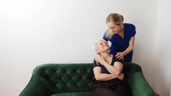 Professional and Helpful Caregiver Comforting Senior Retired Woman at Nursing Home