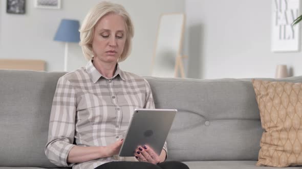 Woman Using Tablet while Relaxing on Sofa