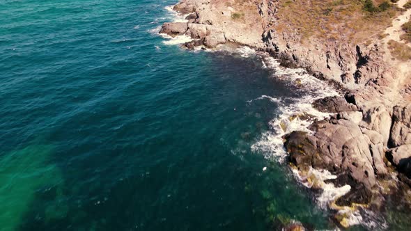 waves crashing cliffs view from drone shot