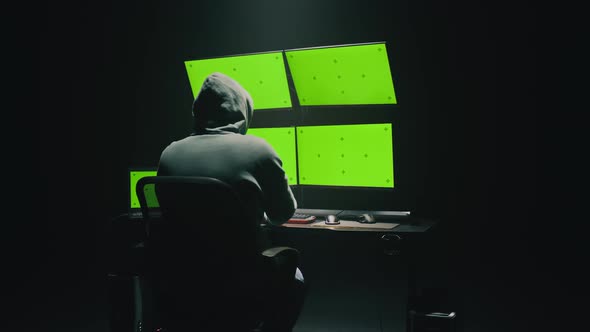 Anonymous Hacker Using Computer in Darkness