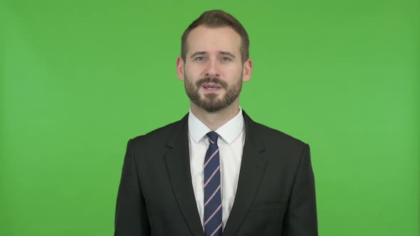 Handsome Businessman Doing Yes Sign By Head Against Chroma Key