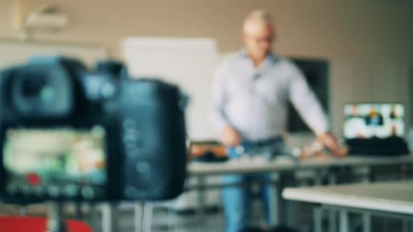 A Camera Is Filming a Male Teacher During an Online Lesson