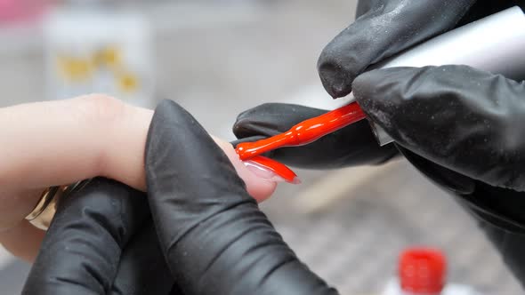 Applying a Layer of Red Varnish to the Nail Surface