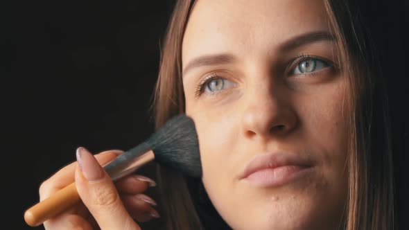 Face of a Beautiful Young Woman Applying Blush with a Brush on Her Face