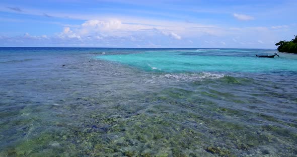 Luxury birds eye tourism shot of a sandy white paradise beach and aqua blue water background in vibr