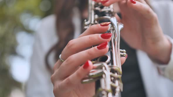 A Girl Plays the Clarinet in the Summer in the Park