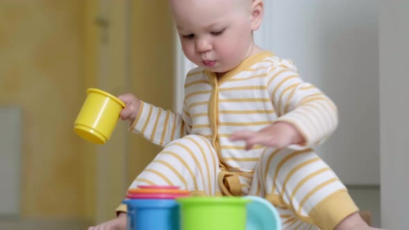 Little Baby Playing with Educational Colorful Toys at Home Sitting on Floor