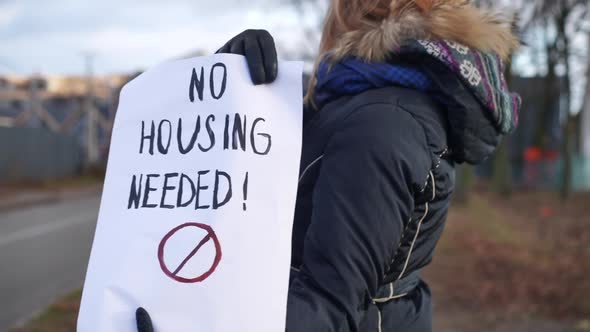 No Housing Needed Placard in Hands of Unrecognizable Caucasian Demonstrator Standing Outdoors