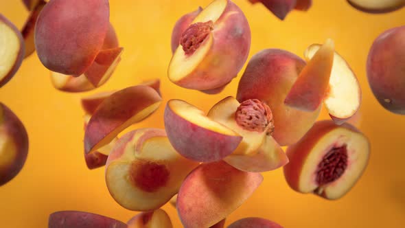 Super Slow Motion Shot of Peach Cuts Flying Towards Camera on Orange Background at 1000 Fps