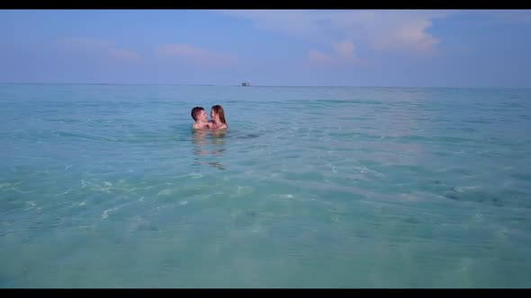 Two people suntan on idyllic sea view beach voyage by blue sea with white sand background of the Mal