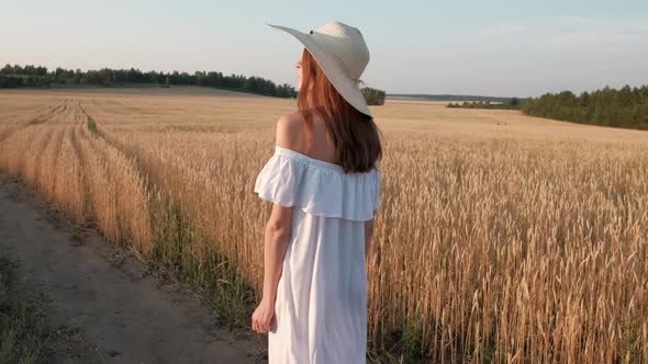 Beautiful Woman Goes to Field of Ripe Golden Wheat