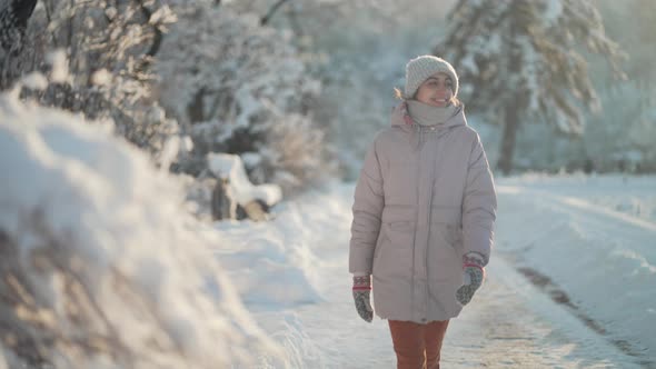 Joyful Beautiful Woman Walking Outdoors in Frosty Park After Snowfall