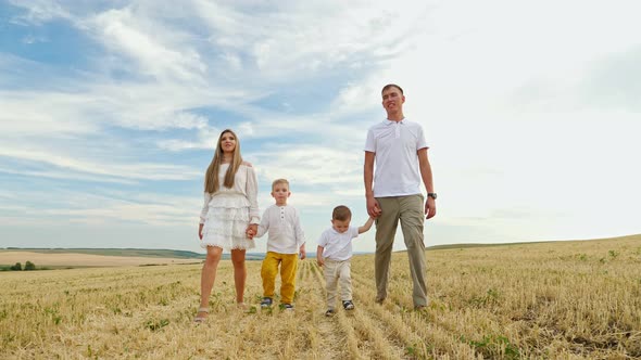 Family Father Mother and Small Children Sons Walk Joining Hands