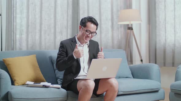 Asian Businessman In Jacket And Shorts Showing Thumbs Up Gesture While Having Video Call On A Laptop