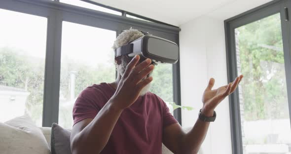 Video of african american senior man using vr headset