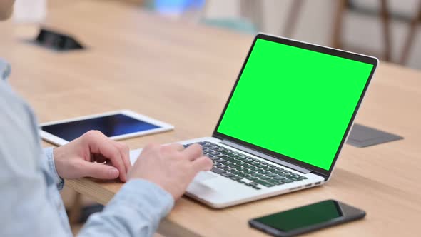 Man Working on Laptop with Green Chroma Key Screen