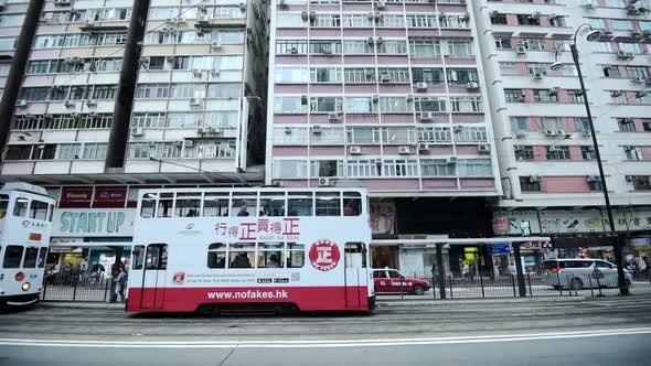 People And Vehicles On The Busy Street In Front Of Commercial And Residential Buildings In Hong Kong