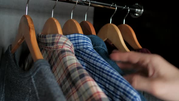Man Chooses Clothes in the Wardrobe