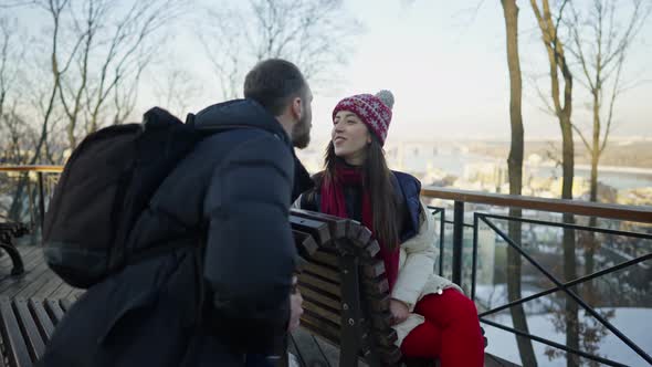 Happy Romantic Couple Haveing a Date on the Bench at Sunny Winter Day