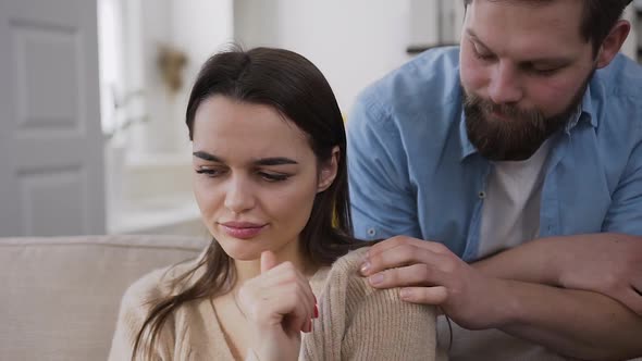 Man Trying to Calm His Upset Hapless Girlfriend and Hugging Her the Back