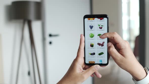 Girl Lying on Couch in Apartment Using Smartphone and Ordering Fresh Fruits and Vegetables in