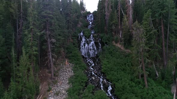 Stunning Waterfall Running Down From Steep Forest Mountains. Aerial Drone Shot