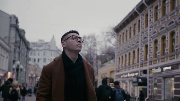 Young Businessman Looks at Buildings on City Center Street Looks Around City