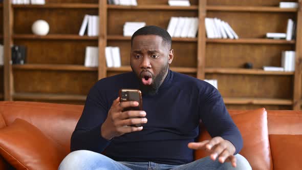 AfricanAmerican Male Employee Using Smartphone Indoor