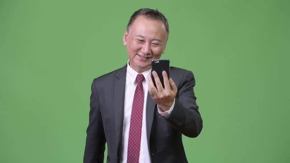 Mature Japanese Businessman Using Phone