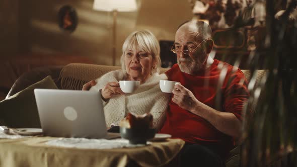 Senior Couple Drinking Tea and Discussing Film