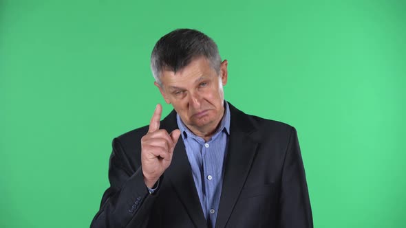 Portrait of Aged Man Shakes His Head Approvingly, Isolated Over Green Background.