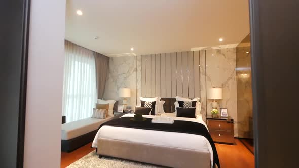 Bedroom furnished with the stylish bedding, couch and lighting furnitures