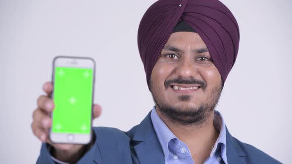 Happy Bearded Indian Sikh Businessman Showing Phone