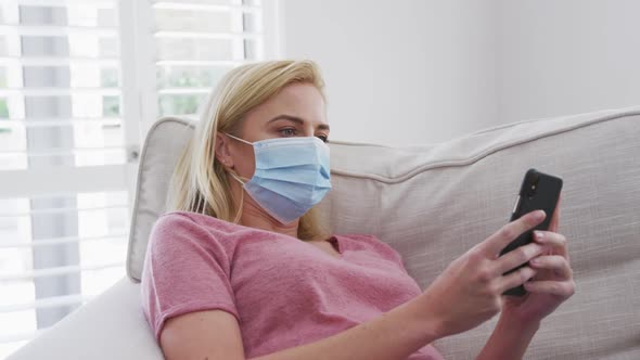 Woman wearing face mask using smartphone