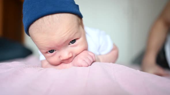 A Baby Sitting on a Bed