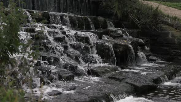 Water flowing over cascading waterfall medium tilting shot