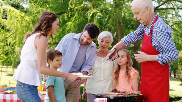 Multi-generation family having their lunch in the park