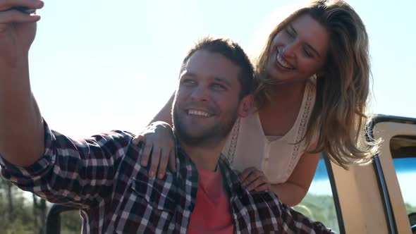 Couple taking selfie with mobile phone near a car 4k