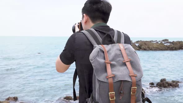 Young Asian Man Photographer Taking Photo of Tropical Island Beach