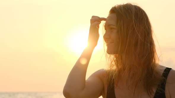 Beautiful Portrait of Blonde Woman with Freckles Happy on Background of Sunset on Sea or Ocean on