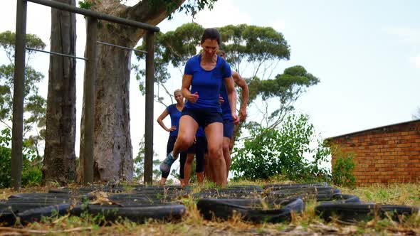 Fit people practicing tire obstacle course training 4k