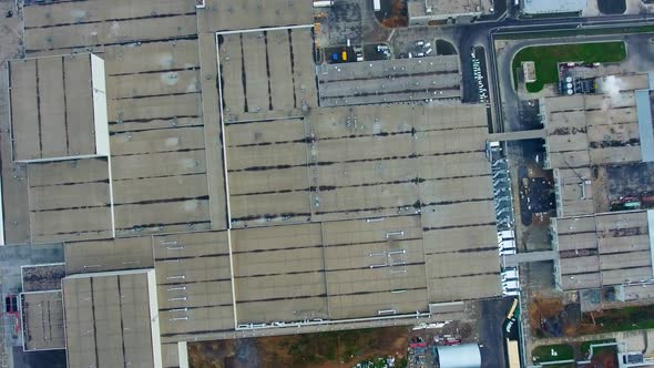 Factory on green field. View from above on industrial territory and many cars nearby. 