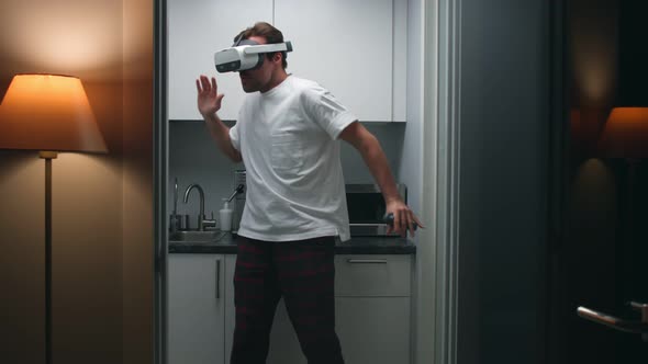 Funny Man in Pajamas Dance in Kitchen in Augmented Reality Headset