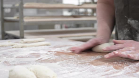 Baker Kneading Dough in a Bakery