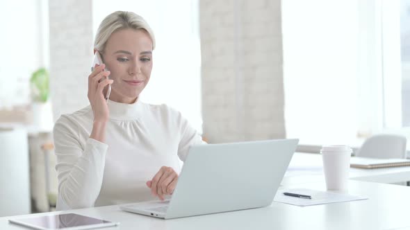 Young Businesswoman Talking on Cellphone in Modern Office