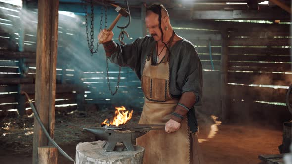 Blacksmith in the Forge Forges a Horseshoe